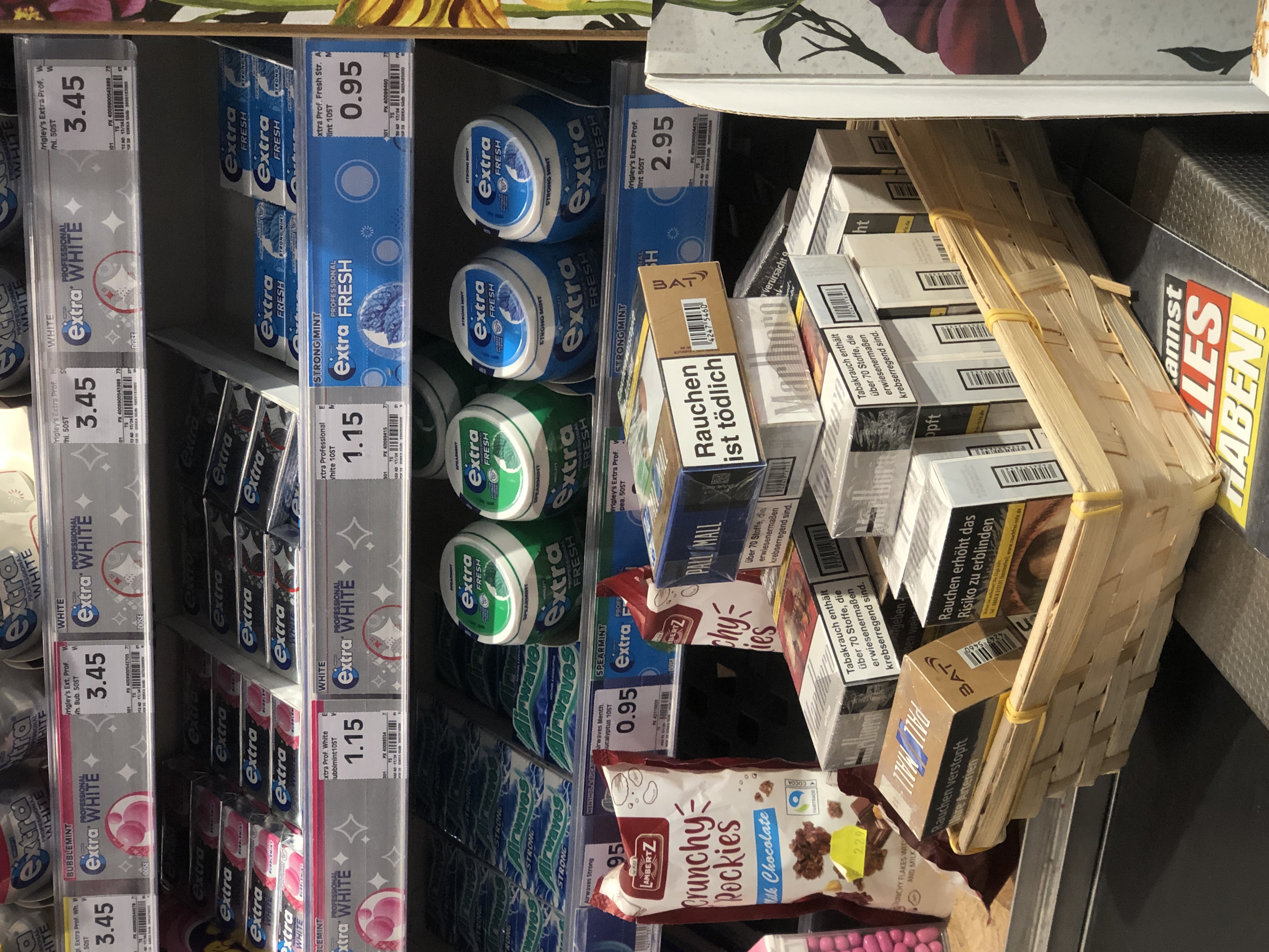 Im Supermarkt stehen Zigarettenschachteln mit Süßigkeiten zum Hingreifen auf dem Laufband